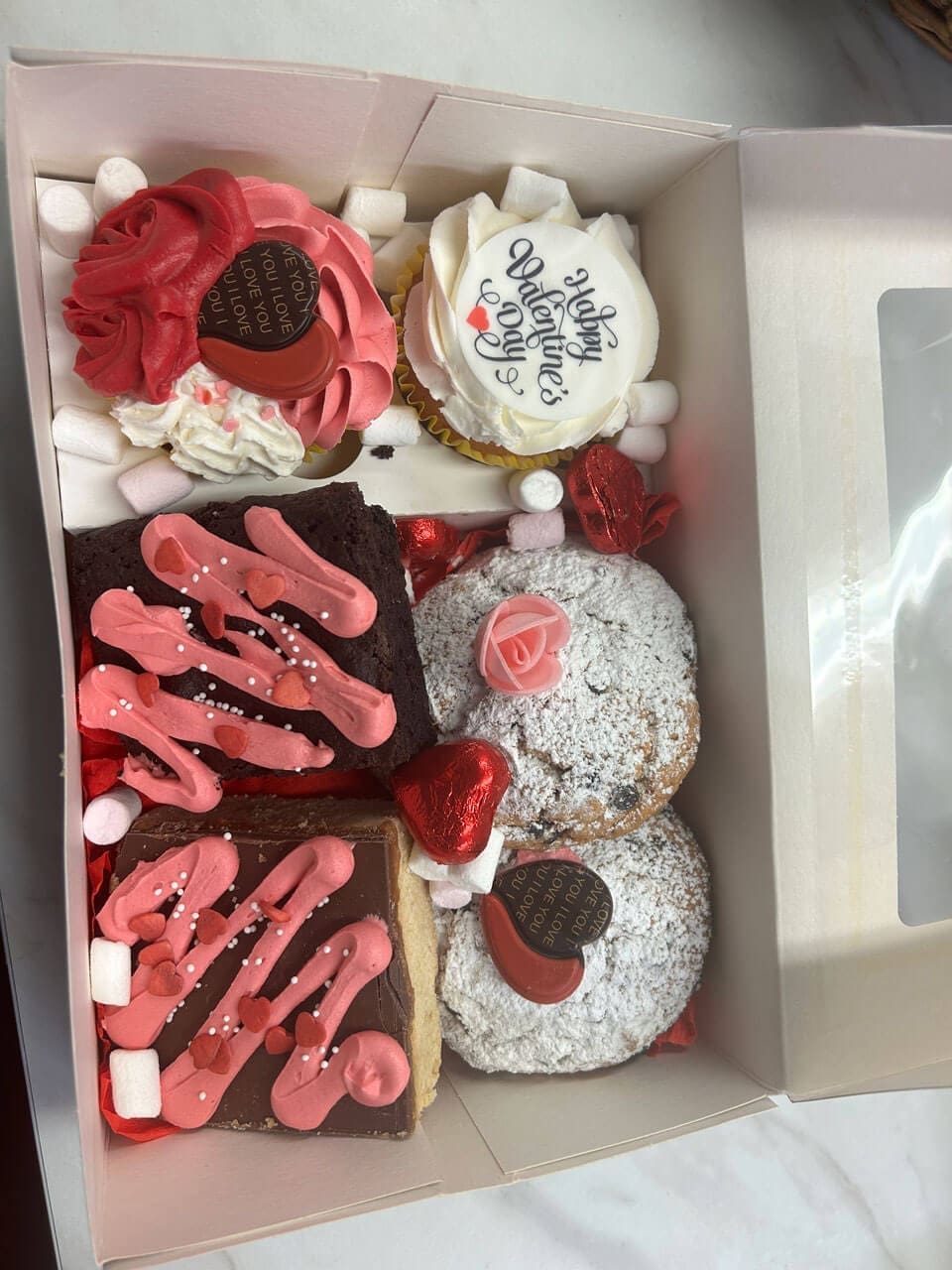 Valentines Treat box with muffins brownies and decorated with pink buttercream and chocolates Doreens Bakery